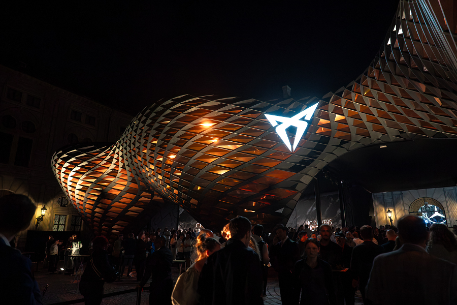 Vista exterior nocturna del espacio CUPRA con piel de cobre